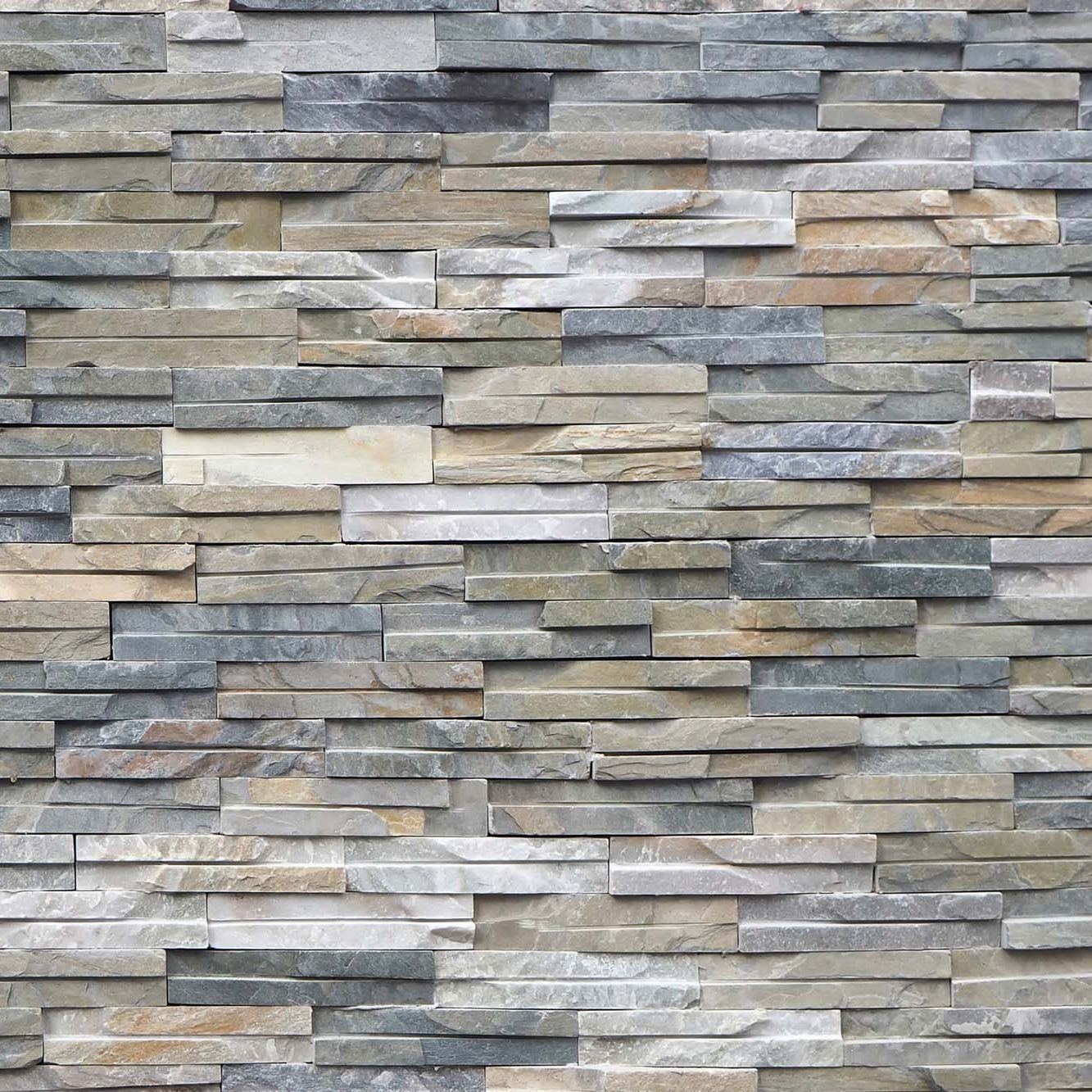 Grey stone wall cladding made of strips and square blocks stacked . Background and texture, close up